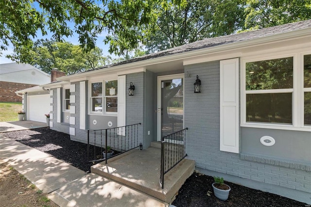 view of front of house with a garage, brick siding, and a chimney