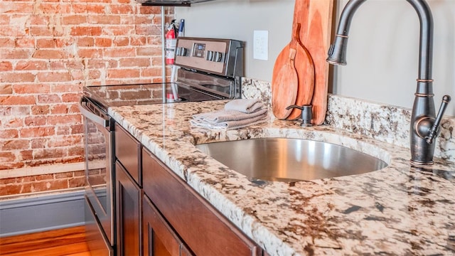 room details with hardwood / wood-style flooring, light stone counters, and electric stove