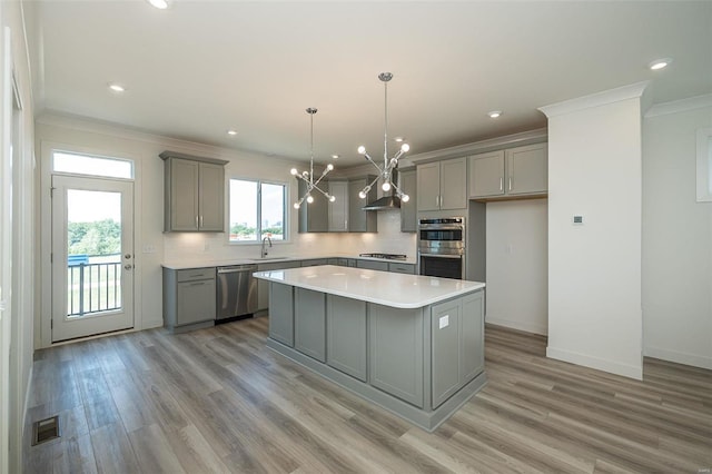 kitchen with a center island, sink, light hardwood / wood-style flooring, gray cabinets, and appliances with stainless steel finishes