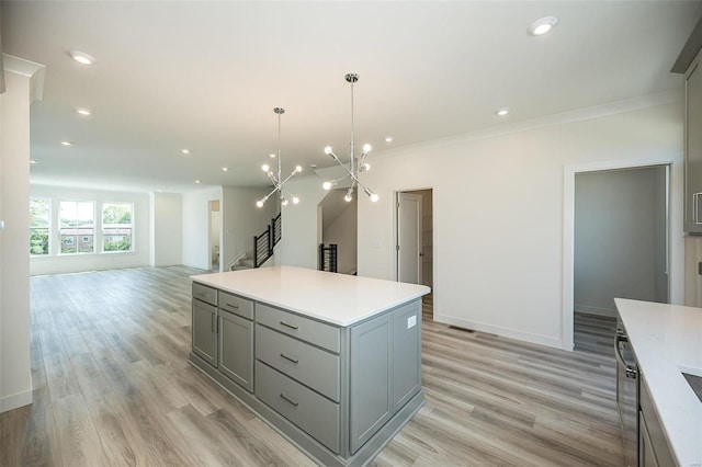 kitchen with a center island, gray cabinets, light hardwood / wood-style floors, and hanging light fixtures