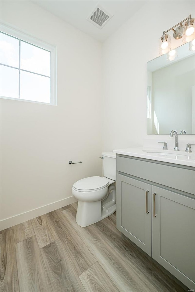 bathroom with vanity, toilet, and wood-type flooring