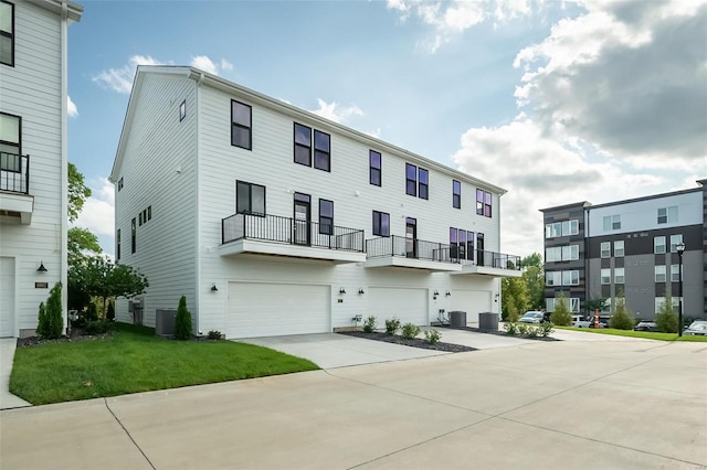 view of property with central AC unit and a front lawn