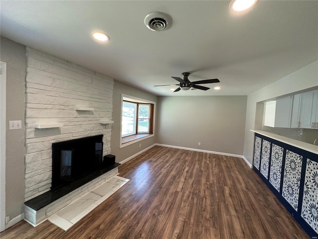 unfurnished living room with ceiling fan, dark hardwood / wood-style floors, and a fireplace