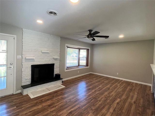 unfurnished living room featuring a fireplace, ceiling fan, and dark hardwood / wood-style flooring