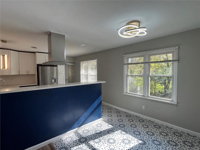 kitchen featuring stainless steel refrigerator with ice dispenser, a wealth of natural light, white cabinetry, and island exhaust hood