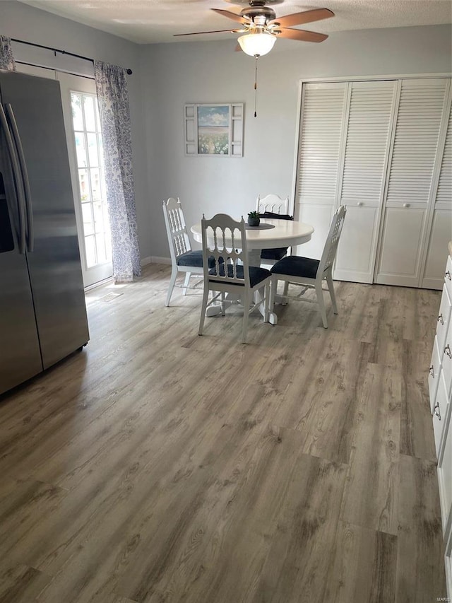 dining space featuring light hardwood / wood-style floors, a textured ceiling, and ceiling fan