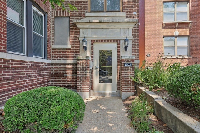 property entrance featuring brick siding