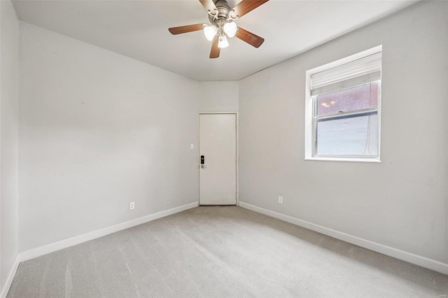 spare room featuring carpet flooring, ceiling fan, and baseboards