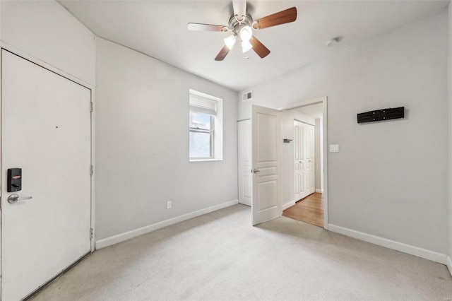 unfurnished bedroom featuring a ceiling fan, light carpet, visible vents, and baseboards