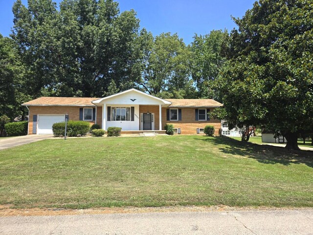 ranch-style home with a garage, a porch, and a front lawn