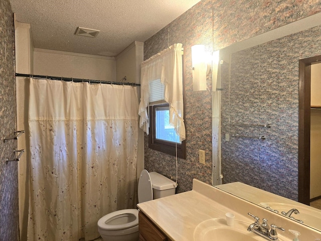 bathroom with toilet, vanity, and a textured ceiling