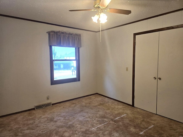 unfurnished bedroom featuring a closet, carpet, a textured ceiling, and ceiling fan