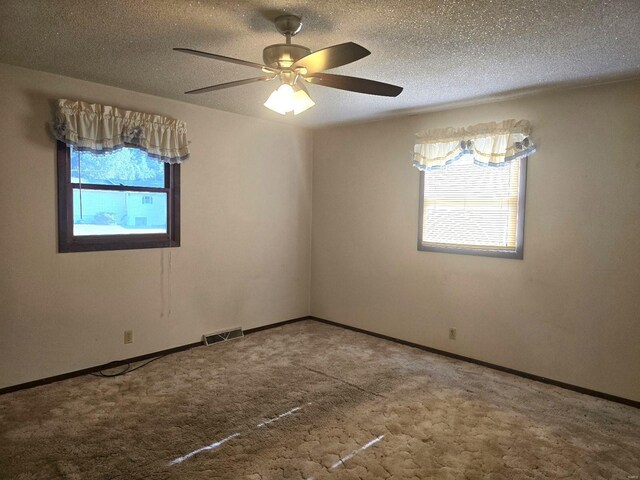 spare room featuring carpet, ceiling fan, and a textured ceiling