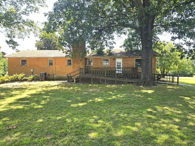 back of house with central AC, a lawn, and a wooden deck