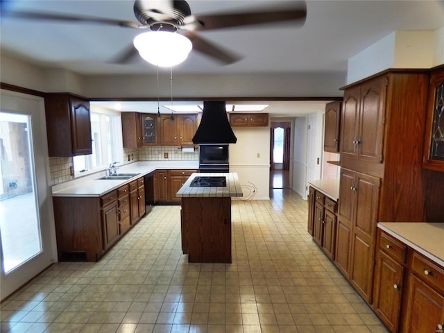 kitchen featuring a healthy amount of sunlight, a kitchen island, backsplash, and custom exhaust hood