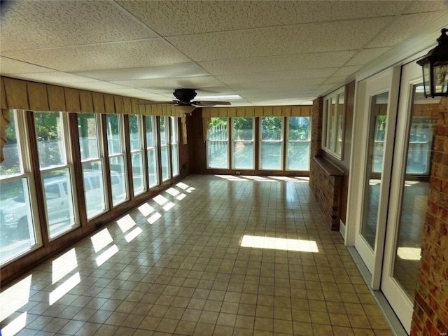 unfurnished sunroom featuring a paneled ceiling and ceiling fan