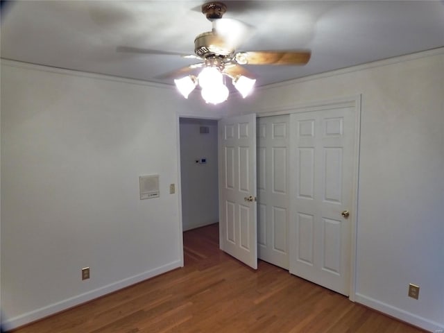 unfurnished bedroom featuring hardwood / wood-style flooring, ceiling fan, and a closet