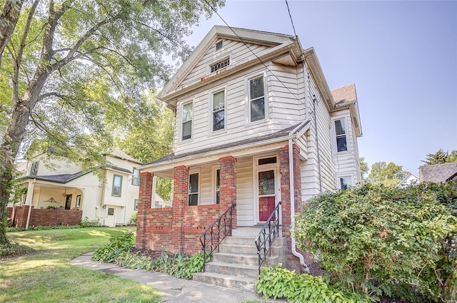 view of front of house with covered porch and a front yard