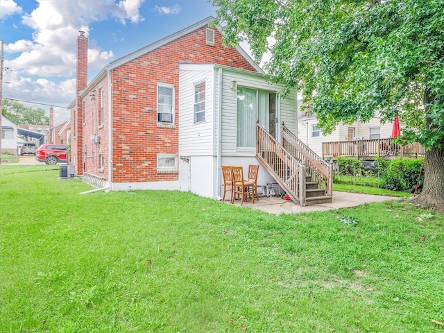 rear view of house featuring a wooden deck, central AC, and a lawn