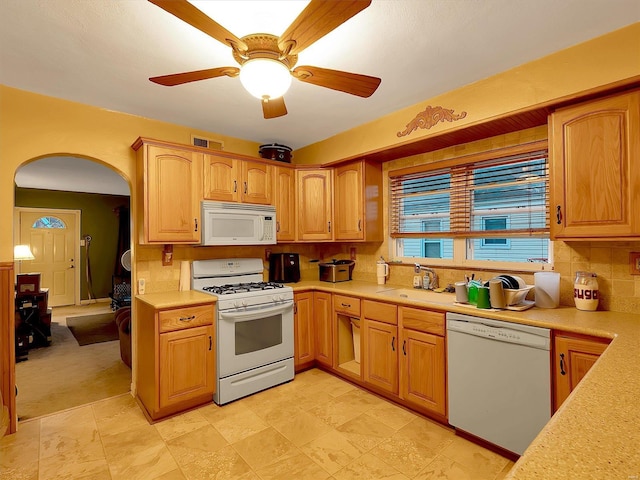 kitchen with decorative backsplash, light colored carpet, white appliances, and ceiling fan