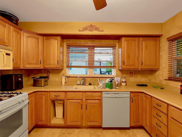 kitchen with sink, a wealth of natural light, backsplash, and white appliances