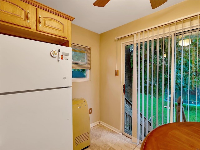 interior space with light tile patterned flooring, white fridge, light brown cabinets, and ceiling fan