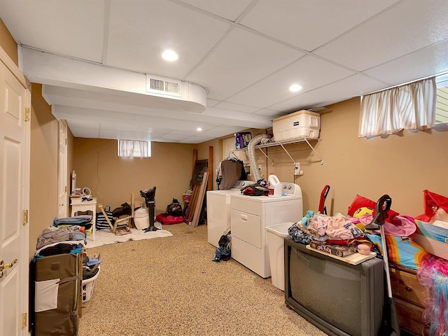 interior space with light colored carpet, a paneled ceiling, and washing machine and clothes dryer