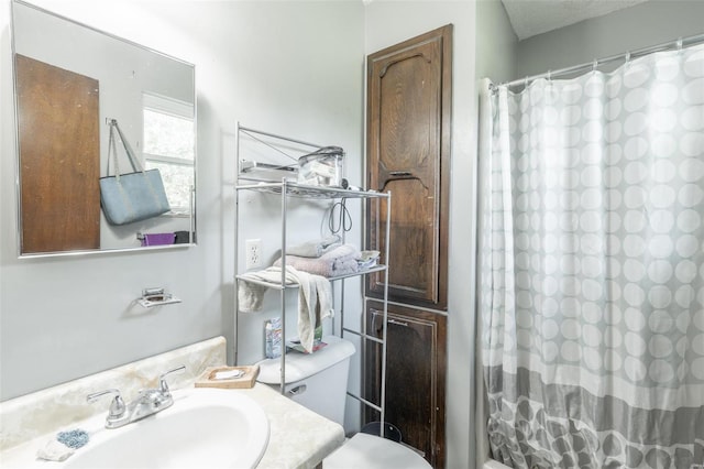 bathroom with curtained shower, vanity, and toilet