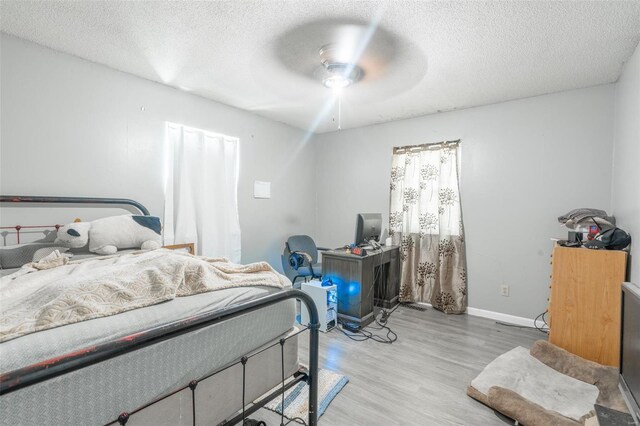 bedroom featuring hardwood / wood-style floors, ceiling fan, and a textured ceiling