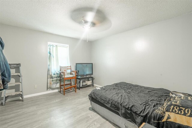 bedroom featuring hardwood / wood-style flooring, a textured ceiling, and ceiling fan