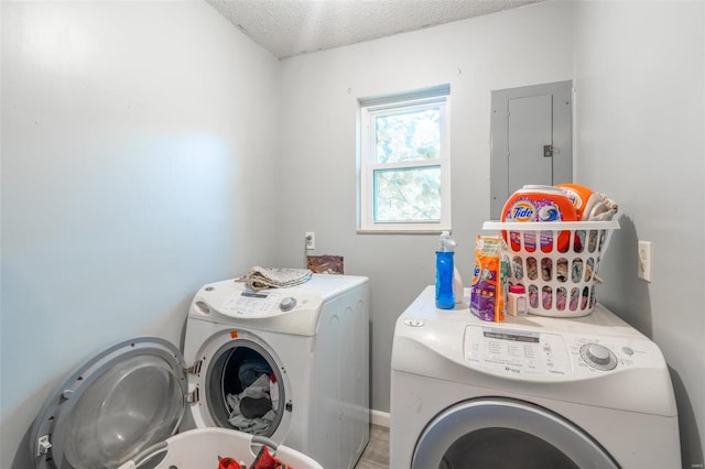 clothes washing area featuring a textured ceiling, wood-type flooring, and washing machine and clothes dryer