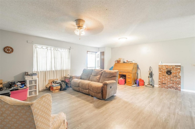 living room with hardwood / wood-style floors, ceiling fan, and a textured ceiling