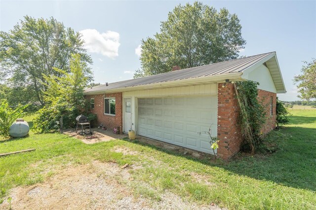 view of side of home featuring a garage and a yard