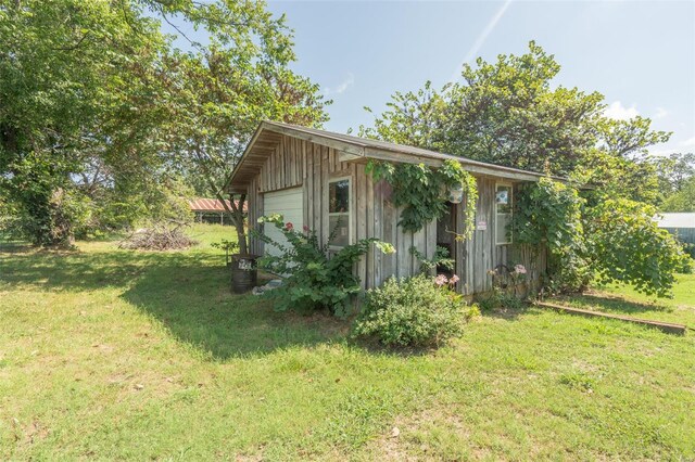 view of home's exterior with a lawn, an outbuilding, and a garage