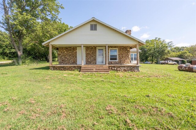 view of front of house with covered porch and a front lawn