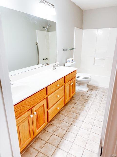 full bathroom with shower / tub combination, vanity, toilet, and tile patterned floors