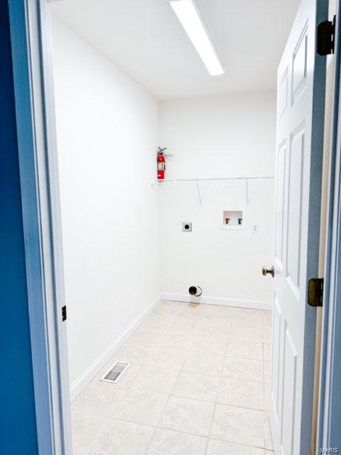 laundry room featuring hookup for a washing machine, light tile patterned floors, and electric dryer hookup