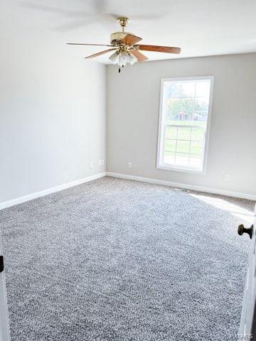 carpeted empty room featuring ceiling fan