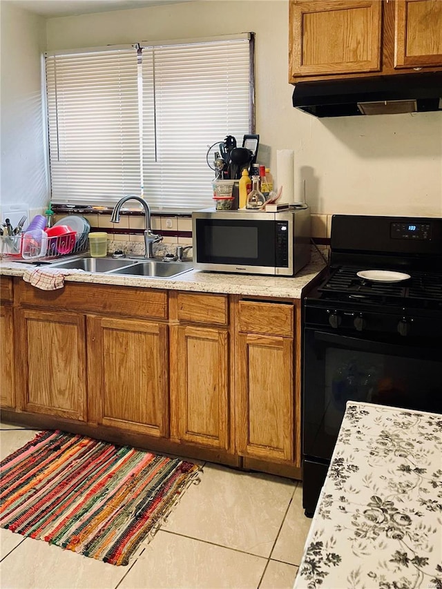 kitchen featuring sink, black range with gas cooktop, light tile patterned flooring, and range hood