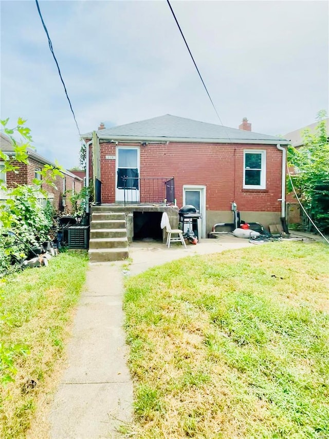 rear view of house featuring a lawn