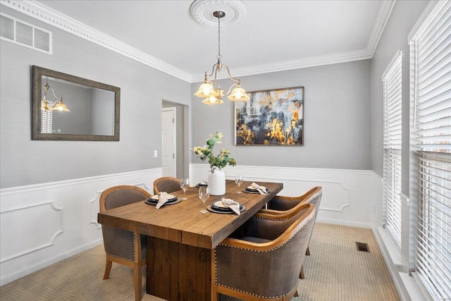 dining space featuring crown molding, a chandelier, and light carpet