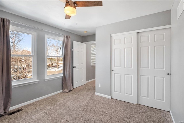 unfurnished bedroom with light carpet, ceiling fan, and a closet