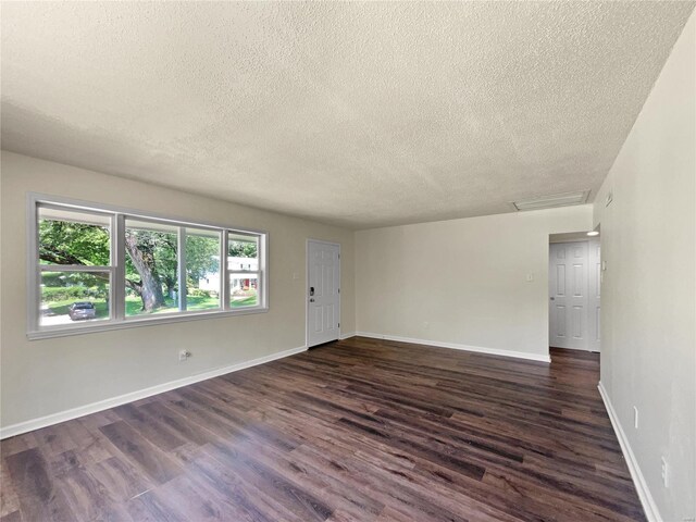 spare room featuring dark hardwood / wood-style floors and a textured ceiling