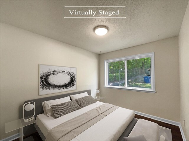 bedroom featuring wood-type flooring and a textured ceiling