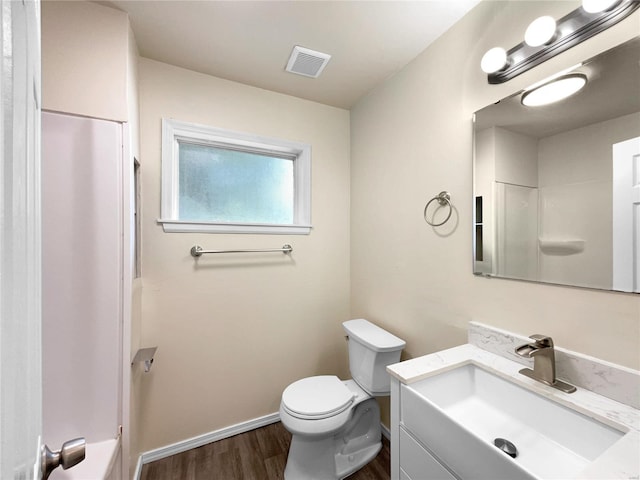 bathroom with hardwood / wood-style flooring, vanity, toilet, and walk in shower