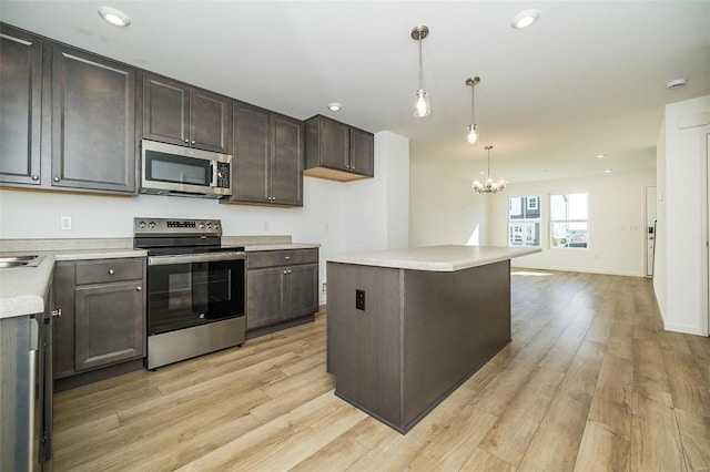 kitchen featuring dark brown cabinetry, stainless steel appliances, light hardwood / wood-style flooring, a chandelier, and pendant lighting