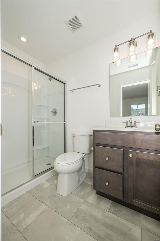 bathroom with tile patterned flooring, vanity, toilet, and a shower with shower door