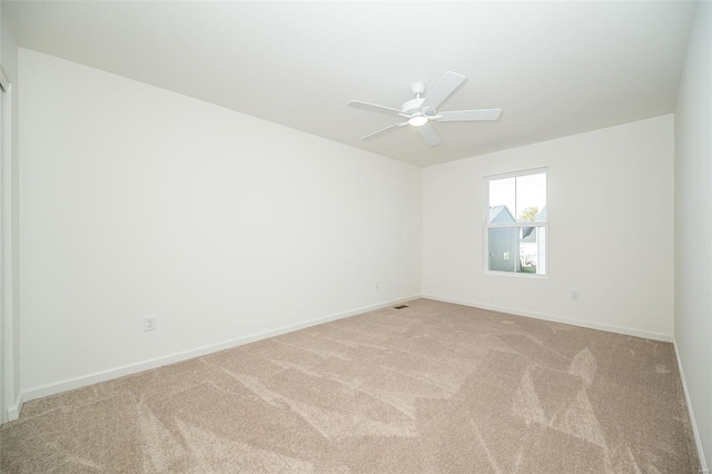 spare room featuring light carpet and ceiling fan