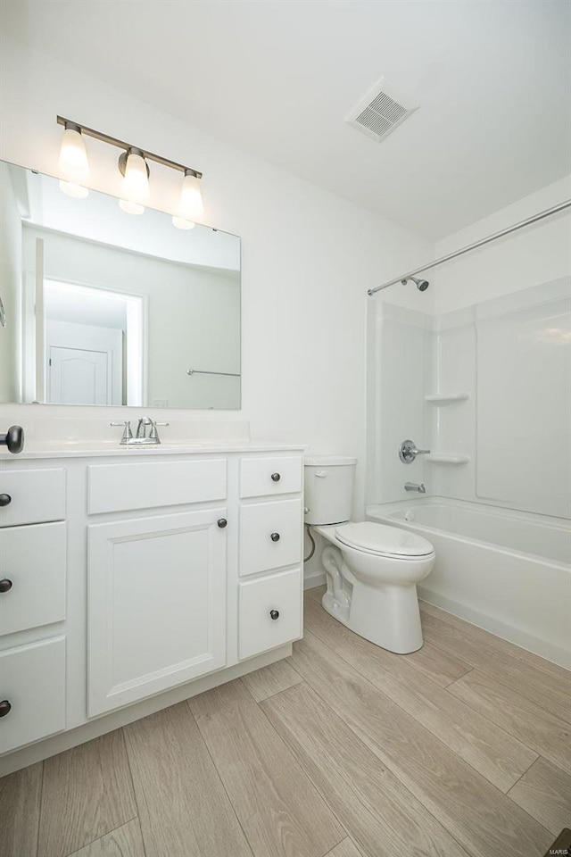 full bathroom with toilet, hardwood / wood-style floors, vanity, and tub / shower combination