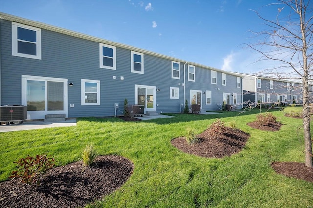 rear view of property featuring a patio, central air condition unit, and a lawn